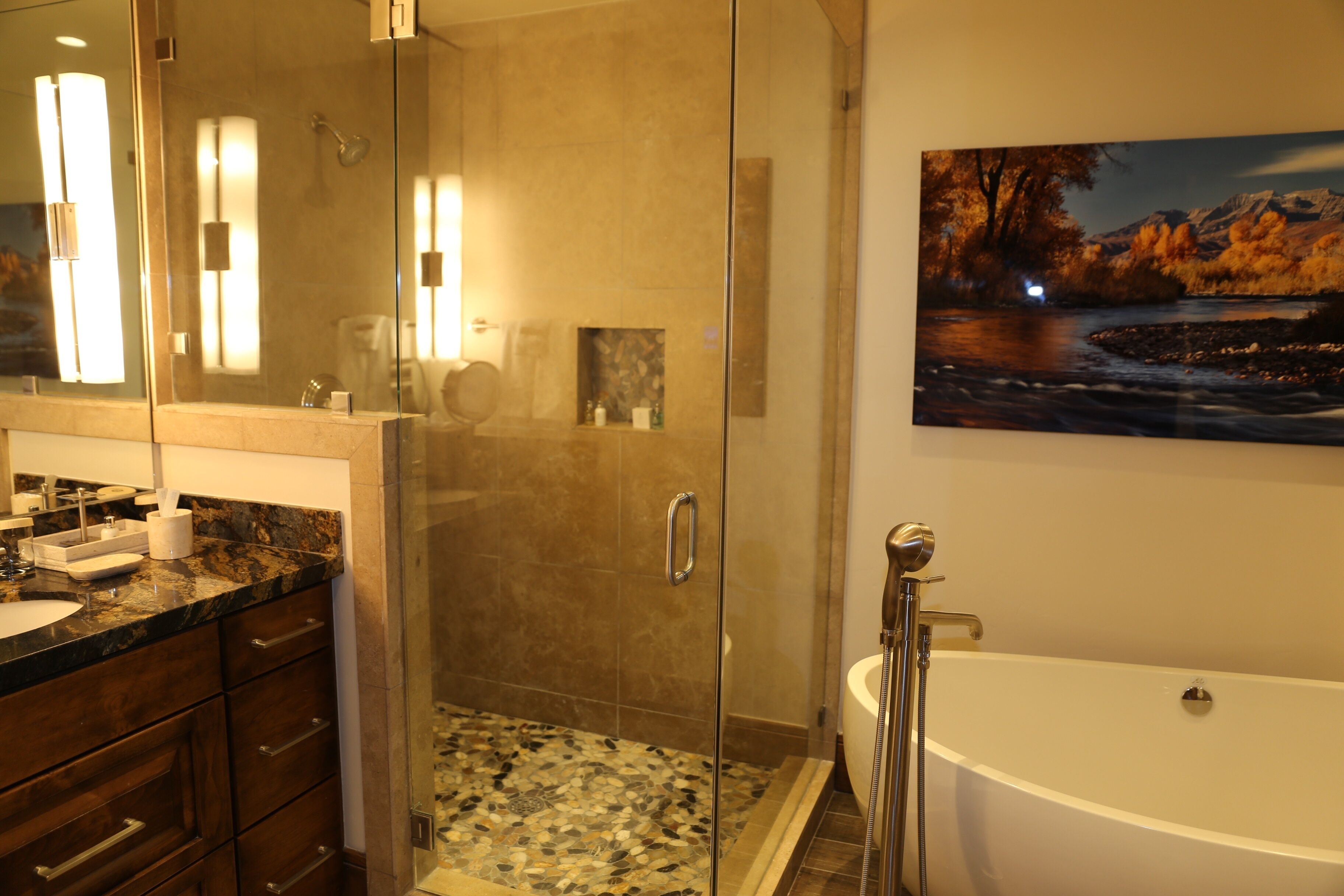 A modern bathroom with a glass-enclosed shower, a freestanding bathtub, and a large mirror with built-in lighting.