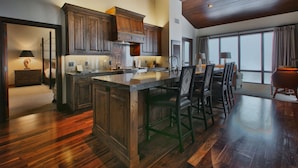 A spacious kitchen with wooden cabinets, a large island, and a dining area with chairs.