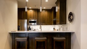 A modern kitchen with wooden cabinets, stainless steel appliances, and a white countertop. - Luxury Four Bedroom Multi-Level Townhouse with Hot Tub 4 Townhouse by RedAwning (Park City)