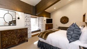 A bedroom with a large bed, a dresser, a TV, and a decorative mirror. - Luxury Four Bedroom Multi-Level Townhouse with Hot Tub 4 Townhouse by RedAwning (Park City)