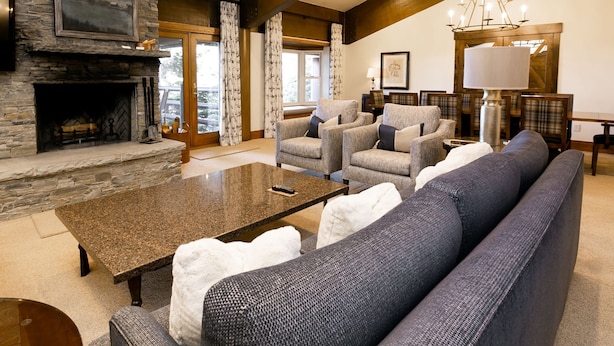A spacious living room with a stone fireplace, comfortable seating, and a chandelier. - Luxury Four Bedroom Multi-Level Townhouse with Hot Tub 4 Townhouse by RedAwning (Park City)