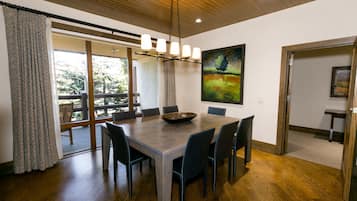 A dining area with a wooden table, chairs, and a chandelier.