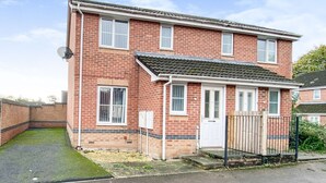 A two-story brick house with a tiled roof, a front door, and a small front yard. - Ammaculate 3 Bedroom Property Near Caltic Manor (Newport)