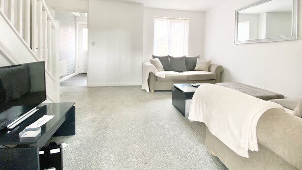 A spacious living room with a sofa, a coffee table, and a TV. - Ammaculate 3 Bedroom Property Near Caltic Manor (Newport)