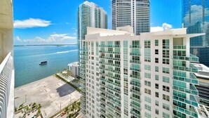 A high-rise hotel with multiple floors, large windows, and a view of the ocean. - Skyline City Views | Pool, Hot Tub & Fitness Room! (Miami)