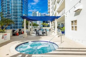 Relax by the circular pool surrounded by a deck and shaded seating area.