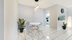 A modern kitchen with white cabinets and a black countertop. - Fuseball & Games - 2 BD / 2 BTH Condo Miami! (Miami)