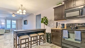 A modern kitchen with a central island, bar stools, a microwave, oven, and a ceiling fan. - 8 Mi to Downtown Little Rock: Home w/ Fenced Yard (Little Rock)