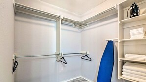 A laundry room with a metal rack, a blue chair, and shelves with folded towels. - 8 Mi to Downtown Little Rock: Home w/ Fenced Yard (Little Rock)