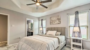 A bedroom with a bed, a ceiling fan, a nightstand, a lamp, and a window with blinds. - 8 Mi to Downtown Little Rock: Home w/ Fenced Yard (Little Rock)