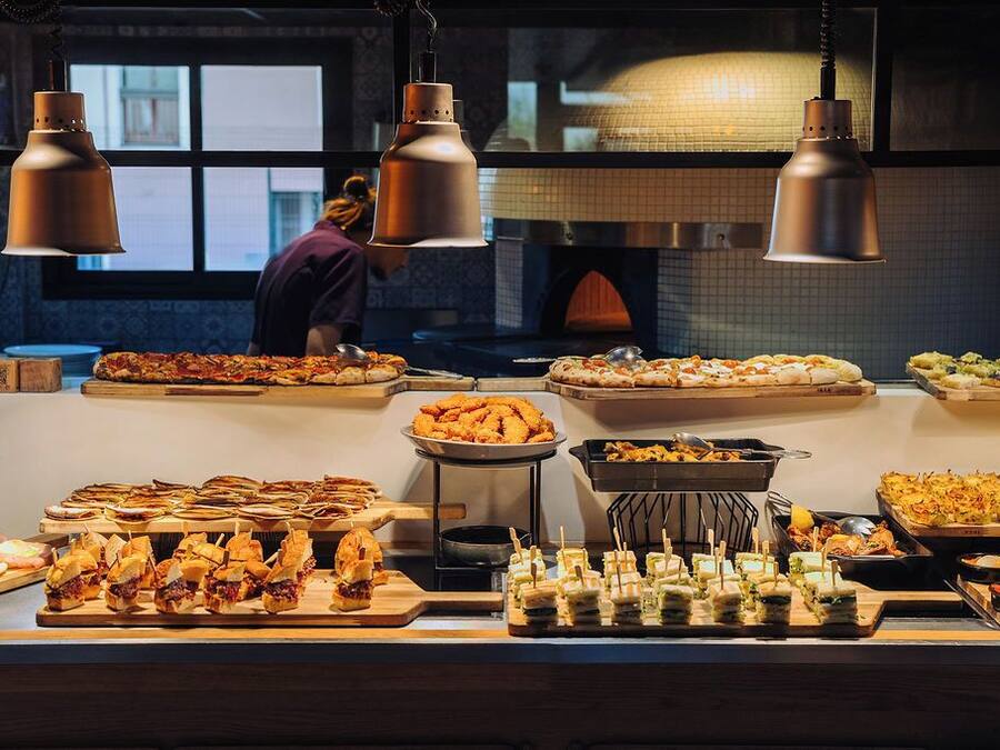 A buffet with various food items and a person in the background.
