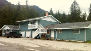 Ein zweistöckiges Haus mit Balkon, Treppe und Garage.