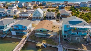A coastal residential area with houses, a wooden pier, and a view of the ocean. - Seahorse Sound | Soundfront + Dock, Gorgeous Views (Topsail Beach)