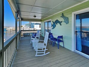 A covered outdoor deck with seating and a view of the marina. - Seahorse Sound | Soundfront + Dock, Gorgeous Views (Topsail Beach)