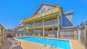 A two-story building with a pool and outdoor seating.