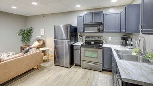 A modern kitchen with stainless steel appliances, grey cabinets, and a marble countertop. - Modern Yankton Apartment Near Riverside Park! (Yankton)