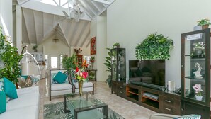 A spacious living room with a large TV, comfortable seating, and various plants. - Villa Decaj - Beautiful 2 bedroom Villa with private pool in Cap Estate (Cap Estate)