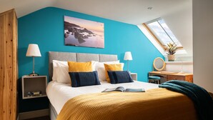A bedroom with a large bed, two bedside tables, a nightstand, a window with a view, and a painting on the wall. - Former Barn in quiet hamlet in Pembrokeshire (Neyland)