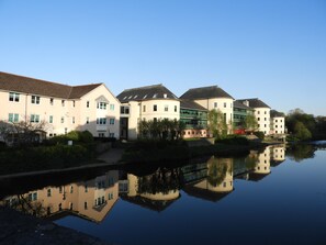 Traditional buildings line the serene riverside, offering a tranquil environment.