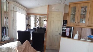 A compact living space with a sofa, a dining area, and a kitchenette.