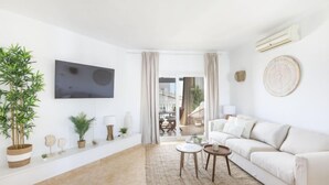 A modern living room with a white sofa, a flat-screen TV, and a large potted plant. - Puerto Banus OPQ by Interhome (Marbella)