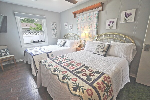 Un dormitorio con dos camas, una ventana con vistas y una silla de madera.