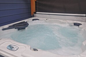 A hot tub with a built-in seat and a control panel, surrounded by a wooden deck. - 2 Doubles in Bed & Breakfast w Hot Tub! (Frankenmuth)