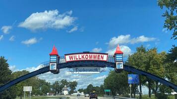 A highway entrance with a 'Willkommen' sign, a white church, and a 'Pure Michigan' sign.