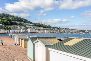 A beach with row houses and a row of beach huts.