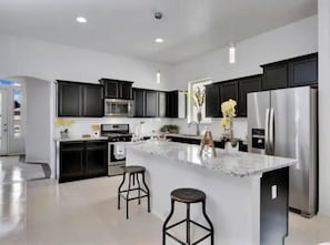 Enjoy cooking in this well-equipped kitchen with a central island, oven, and refrigerator.