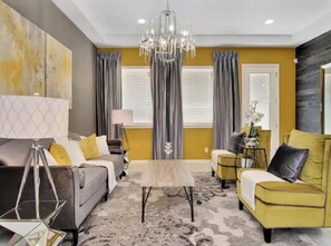 Relax in this stylish living room with a large sofa, armchair, and coffee table.