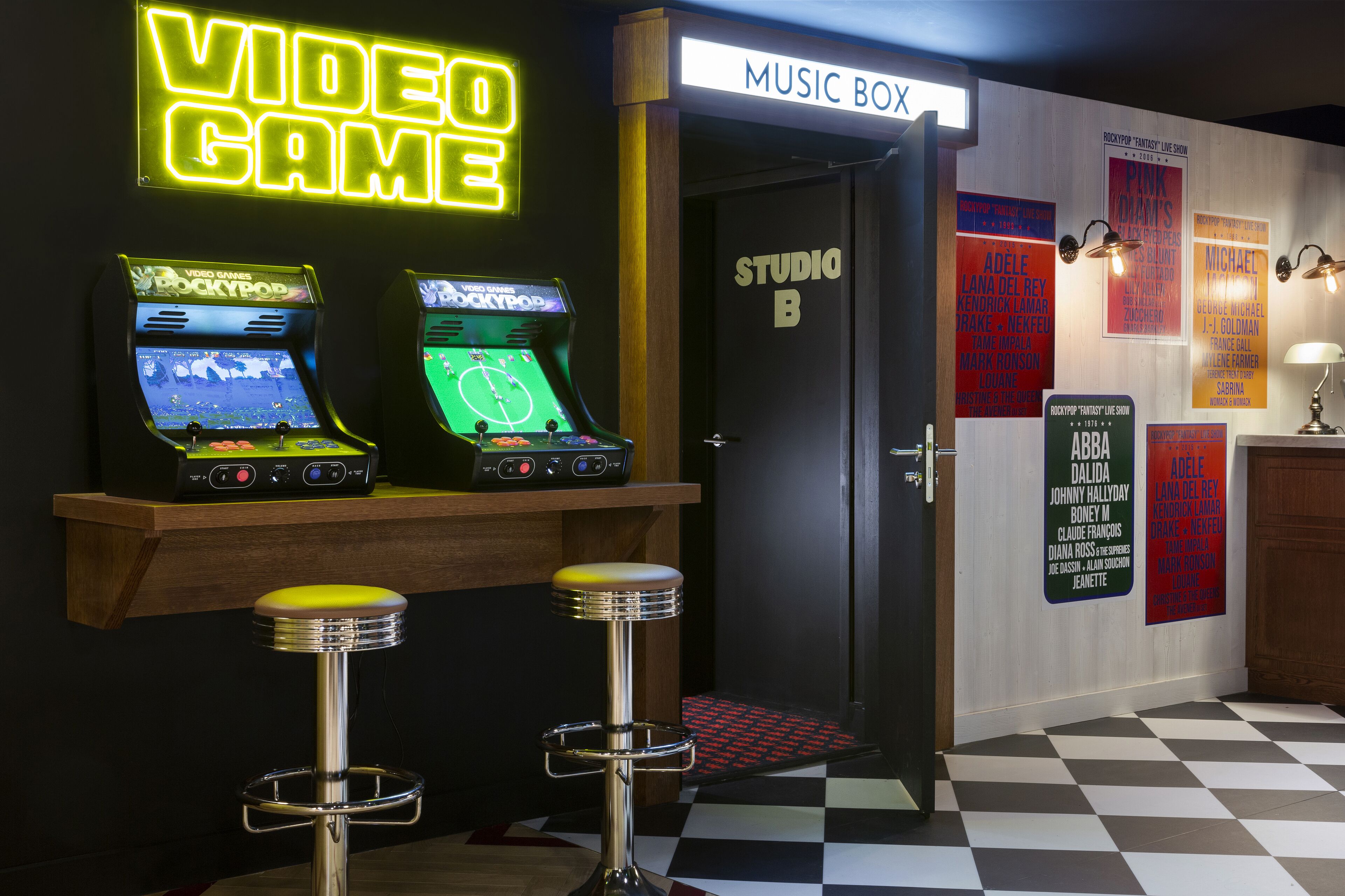 Un área de bar con juegos de arcade, una caja de música y un suelo a cuadros.
