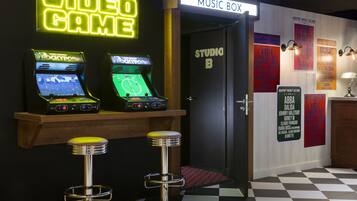 Un área de bar con juegos de arcade, una caja de música y un suelo a cuadros.