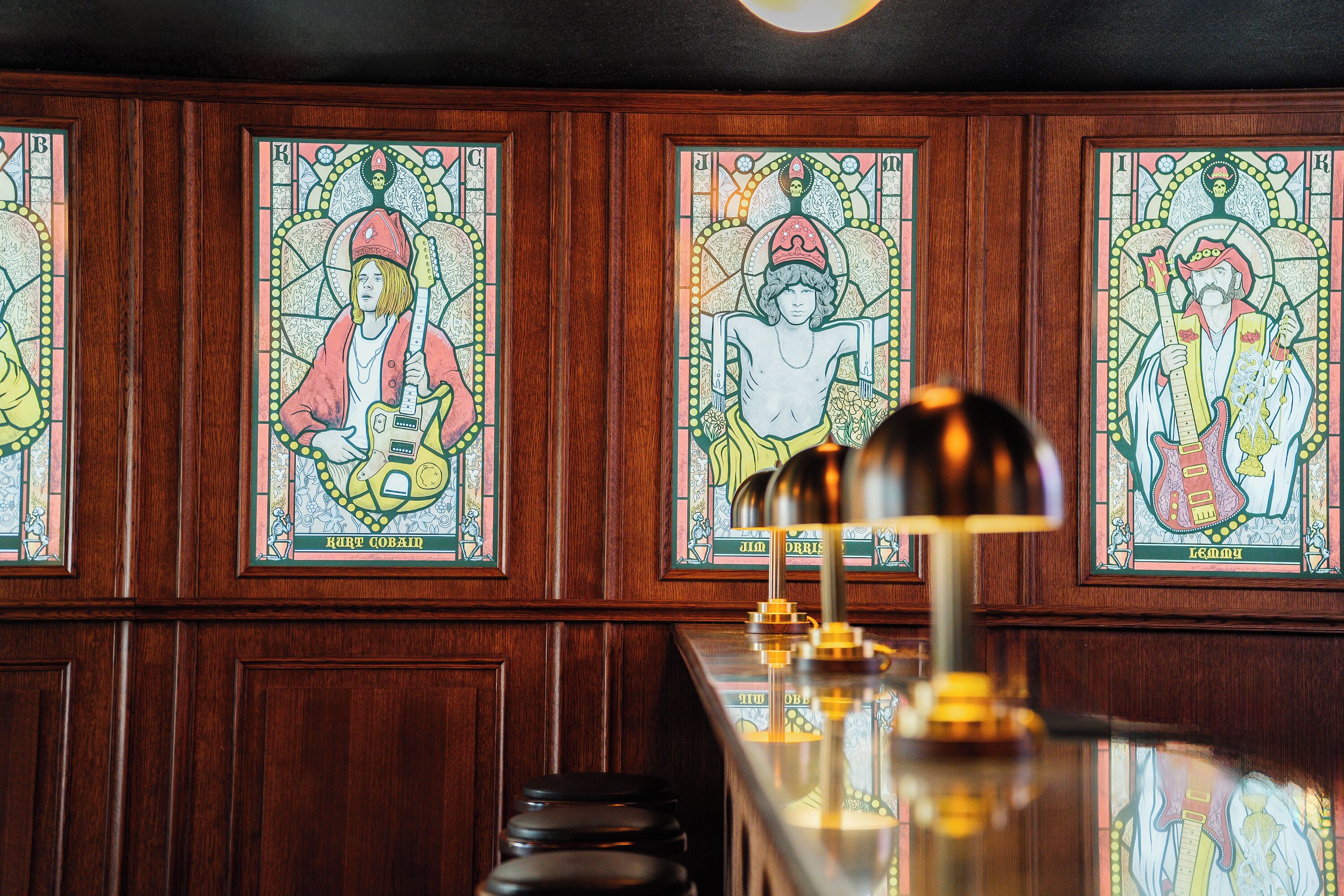 Un bar aux murs lambrés et aux vitraux représentant des musiciens.
