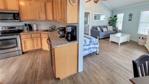 A spacious kitchen with wooden cabinets, a microwave, and a coffee maker. - Beach Joy! GOLF CART included! 2-min BEACH walk, Sleeps 6!! (St. George Island)