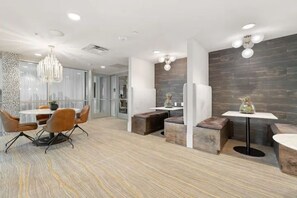 Collaborative workspace with a central table, comfortable seating, and ample lighting.