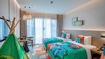 Habitación de hotel con cama, escritorio, silla, ventana con cortinas y vista al exterior.