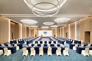 A conference room with rows of tables, chairs, and a large screen at the front. - Holiday Inn Resort Guiyang Qingyan (Guiyang)