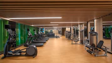 Un gimnasio con cintas de correr, elípticas y equipos de levantamiento de pesas.