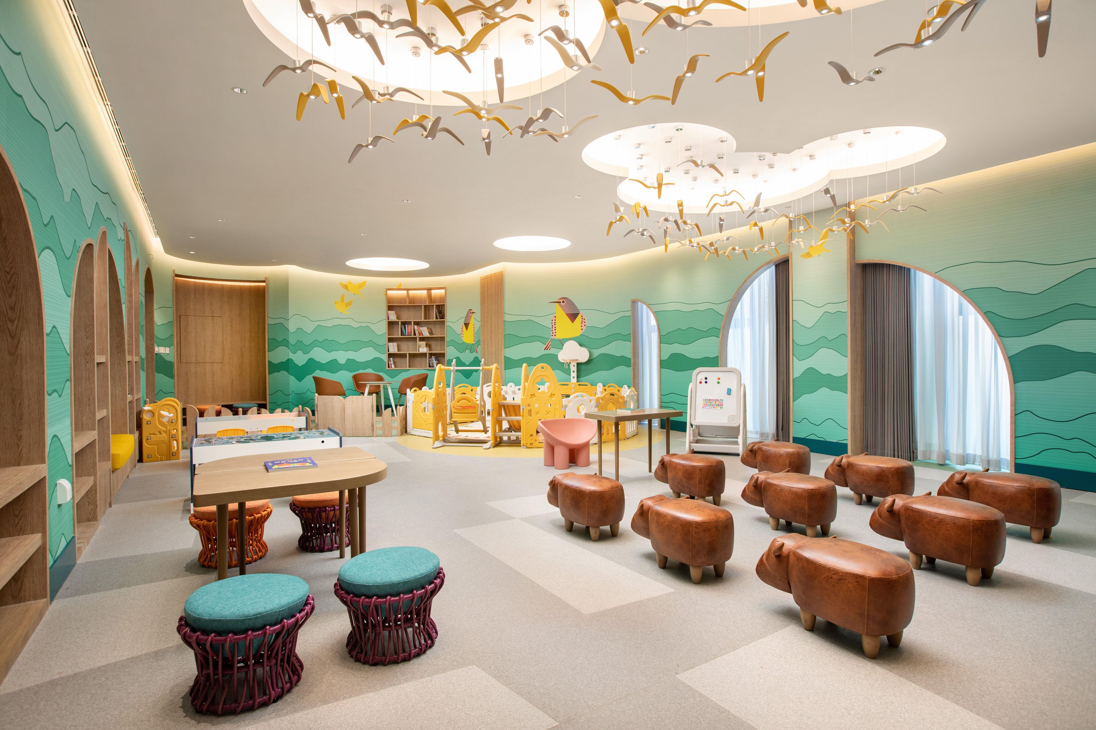 A children's playroom with a table, chairs, and animal-shaped stools.
