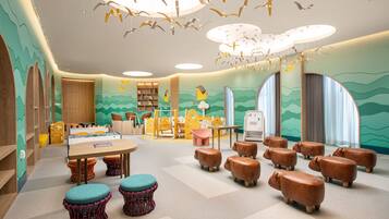 A children's playroom with a table, chairs, and animal-shaped stools.