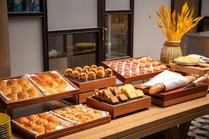 A buffet with various baked goods and pastries.