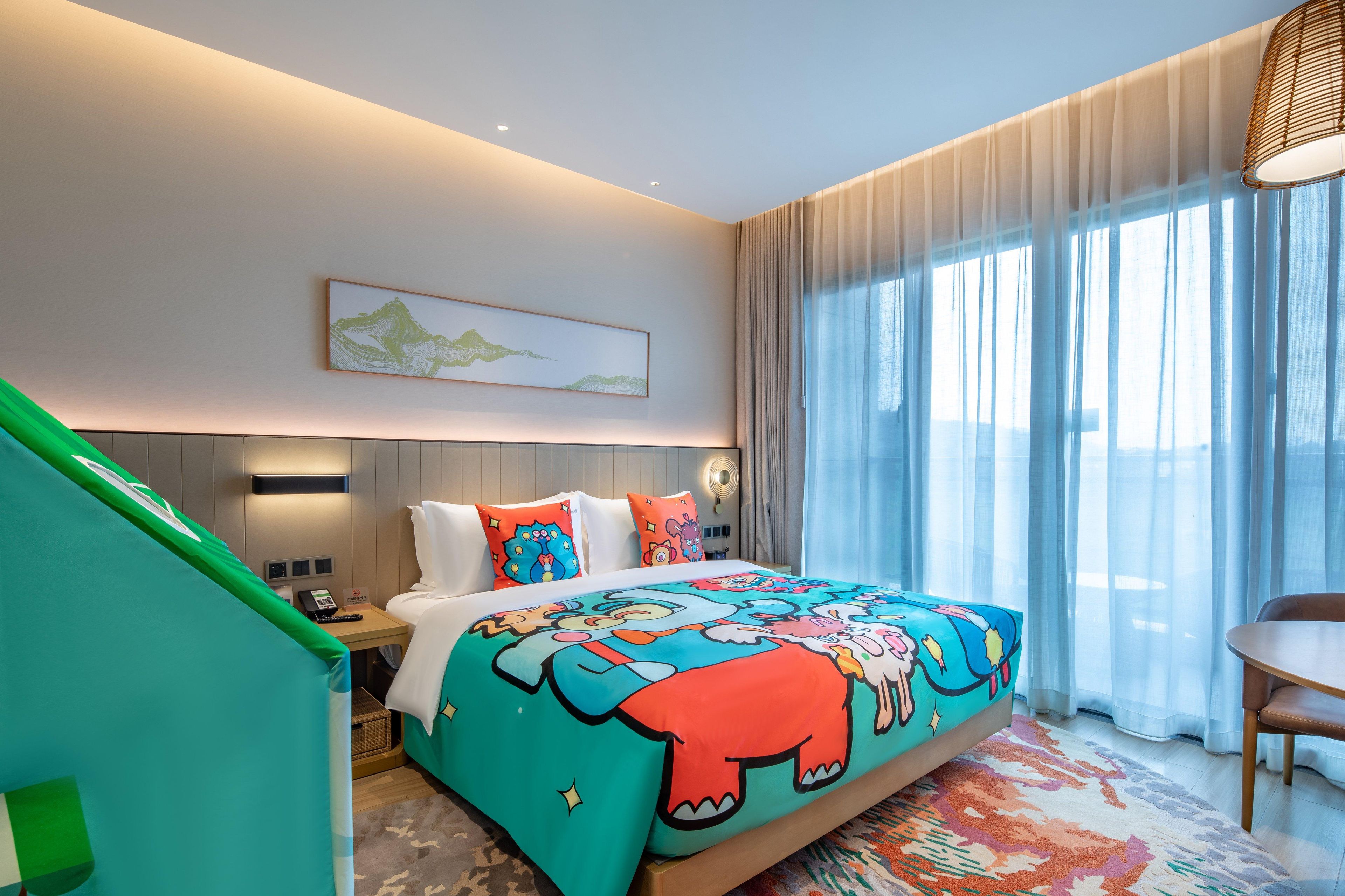 A hotel room with a bed, a desk, a chair, and a window with curtains.