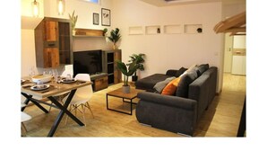 Ein modernes Wohnzimmer mit Essbereich, Kamin und einer Couch.