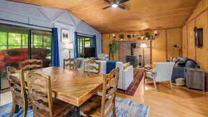 A cozy cabin interior with a dining area, a fireplace, and a living room.