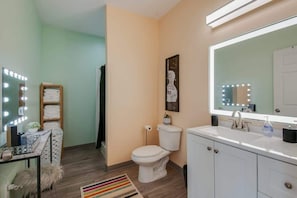 Une salle de bain avec un meuble-lavabo, un évier et des toilettes.