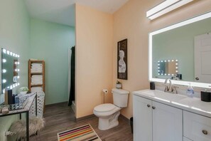A bathroom with a vanity, sink, and toilet.