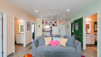 Relax in this stylish living room with a sofa, colorful rug, and framed artwork.