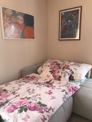 Cozy bedroom with a single bed, framed artwork, and a neat, tidy atmosphere.