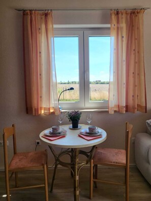 Enjoy meals for two in this cozy dining area with a round table, floral centerpiece, and comfortable seating.